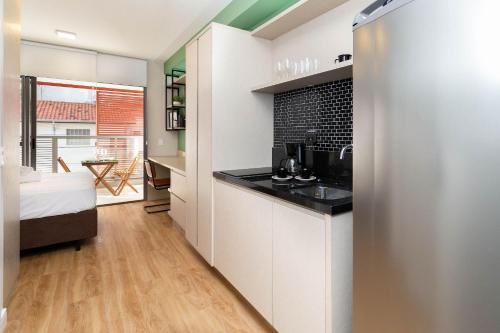 a kitchen with white cabinets and a black counter top at Axis Vila Mariana - Studios por temporada in Sao Paulo