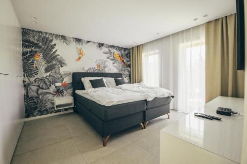 um quarto com uma cama e um papel de parede tropical em Lenneapartments Premium em Plettenberg