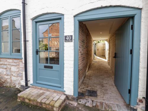 a blue door on a brick building with a hallway at Tannery Cottage in Much Wenlock