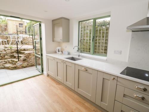 a kitchen with a sink and a large window at Tannery Cottage in Much Wenlock