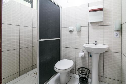 La salle de bains est pourvue de toilettes et d'un lavabo. dans l'établissement Grand Prix Hotel, à Cascavel