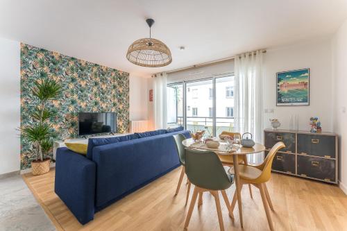 un salon avec un canapé bleu et une table dans l'établissement Lima - Appt à proximité de lIle de Nantes, à Nantes