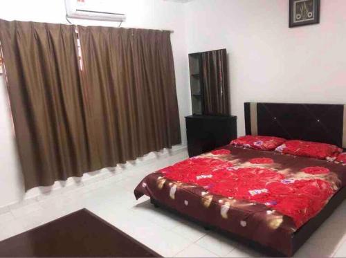 ein Schlafzimmer mit einem großen Bett mit roter Bettwäsche in der Unterkunft Anggerik homestay Klia Klia2 in Sepang