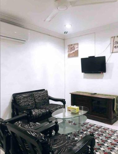ein Wohnzimmer mit einem Ledersessel und einem Tisch in der Unterkunft Anggerik homestay Klia Klia2 in Sepang