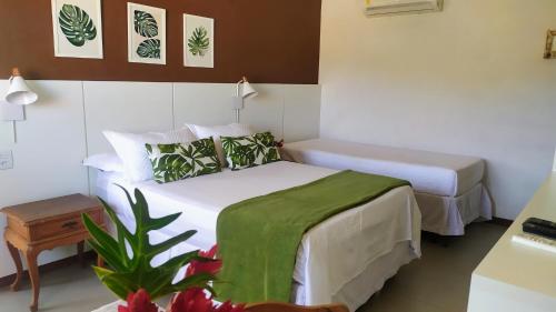 um quarto de hotel com duas camas e uma planta em Terrazzo Suites em Capitólio