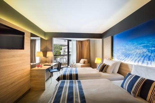 um quarto de hotel com duas camas e uma televisão em Hotel Admiral - Liburnia em Opatija