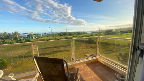 a balcony with chairs and a view of a field at Tamowan in Donghe
