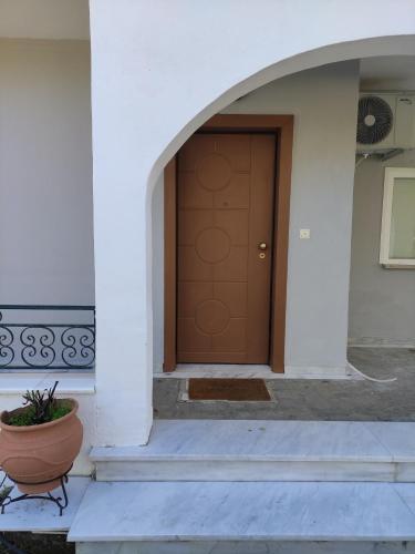 a front door of a white building with a plant in a pot at TERRA LUXURY HOME in Drama