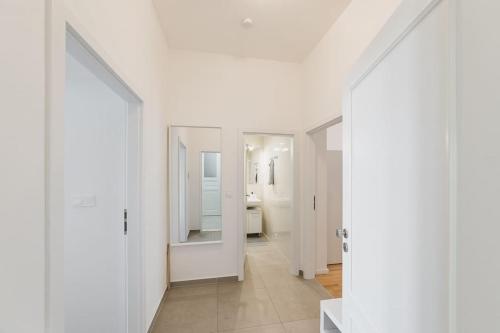 um corredor branco com paredes brancas e um espelho em Bonita Vista Apartment em Praga