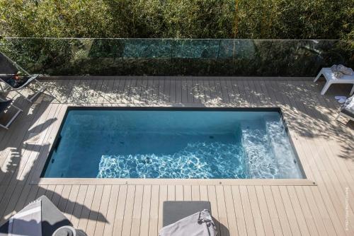 a swimming pool on a deck with a table and a chair at Deluxe VILLA GRAZIELLA 200 M FROM THE BEACH in Èze