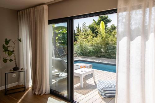 a living room with a sliding glass door leading to a pool at Deluxe VILLA GRAZIELLA 200 M FROM THE BEACH in Èze