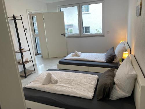 2 Betten in einem Zimmer mit 2 Fenstern in der Unterkunft Business Suite 04 mit Netflix Premium & Parkplatz, zentral zu Audi & Schwarz Gruppe with Fußbodenheizung in Bad Friedrichshall