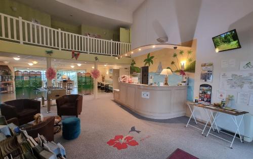 a shop with a counter and chairs in a room at Hôtel Le Kolibri in Tournus