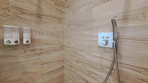 a bathroom with wooden walls and a shower stall with two toilets at Le Boisseliège in Liège