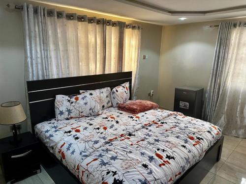a bedroom with a bed with a comforter and pillows at Osmosis Ikoyi in Lagos