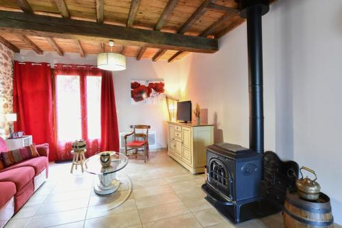a living room with a couch and a stove at La bourdenabo in Lasseubetat