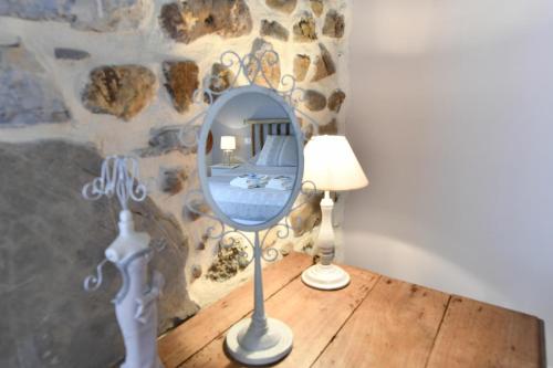 a mirror sitting on a table next to a lamp at La bourdenabo in Lasseubetat