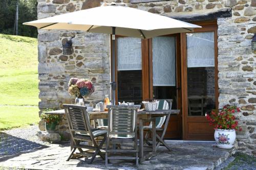 a table and chairs under an umbrella on a patio at La bourdenabo in Lasseubetat