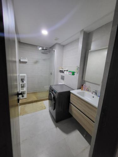 a bathroom with a washing machine and a sink at Magnifique appartement de 3 chambres spacieuses vue sur piscine in Tamaris