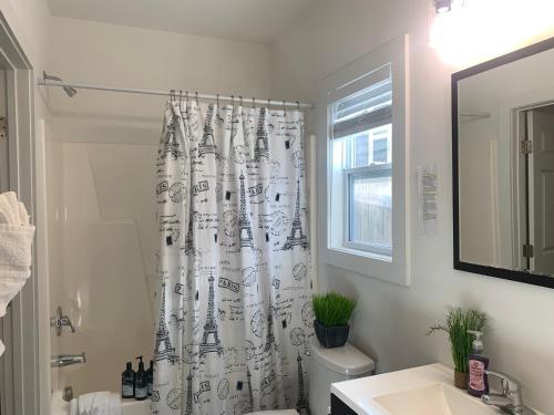 a bathroom with a toilet and a shower curtain at The Popular Pad in Downtown Raleigh, NC in Raleigh