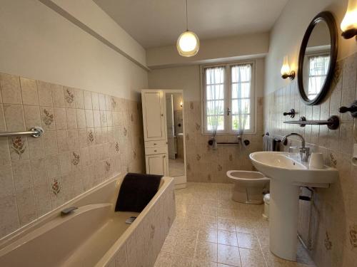 un bagno con vasca, lavandino e WC di Maison puyoo a Thèze
