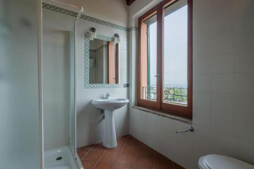 bagno con lavandino, doccia e specchio di Casale Nocciolo 9 a Bevagna