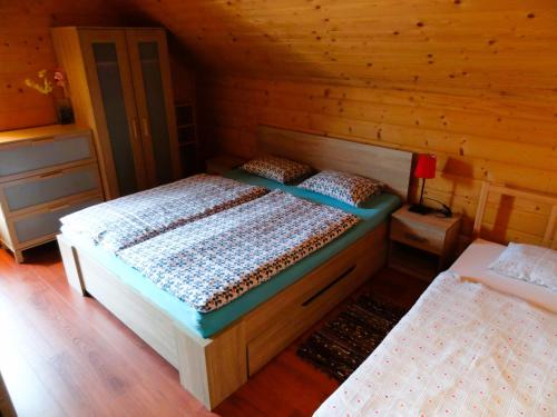 1 dormitorio con 2 camas en una cabaña de madera en Zrub Alpinus en Pribylina