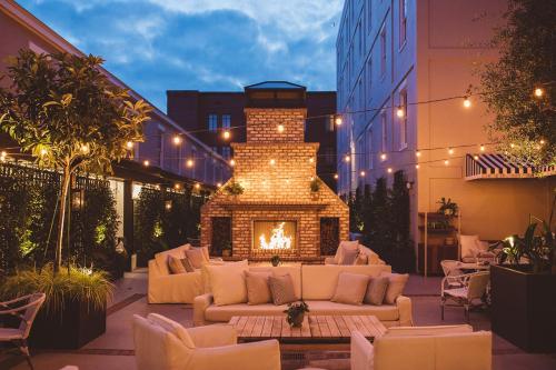 un patio con chimenea con sofás y chimenea en Hotel Emeline en Charleston