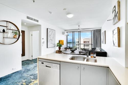 eine Küche mit einem Waschbecken und ein Wohnzimmer in der Unterkunft 901 Harbour Lights with Ocean Views in Cairns