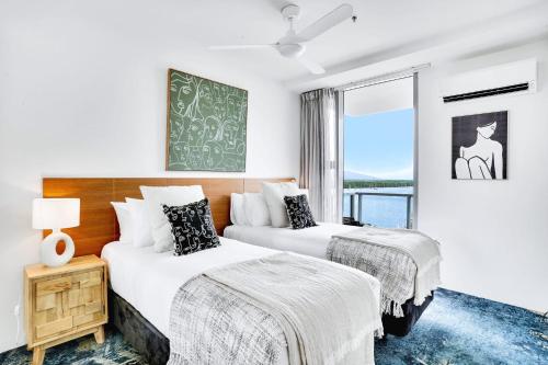 2 Betten in einem Zimmer mit Fenster in der Unterkunft 901 Harbour Lights with Ocean Views in Cairns