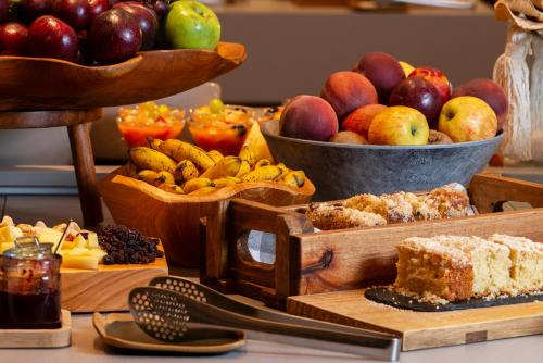 a table with bowls of fruit and plates of cakes at Laghetto Stilo São Paulo in Sao Paulo