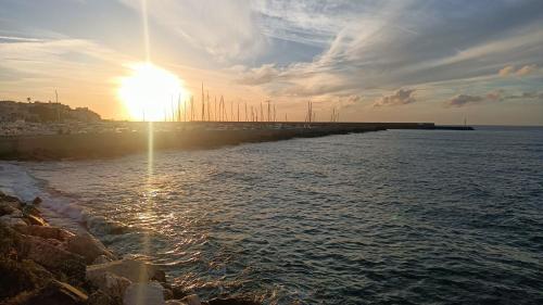 a sun setting over the water near a pier at Suite Giulia in Ischia