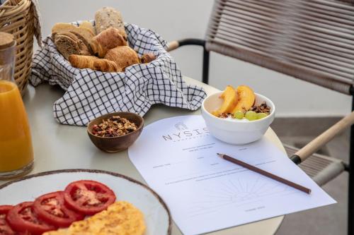 a table with a plate of food and a bowl of fruit at Nysis Koufonisia in Koufonisia