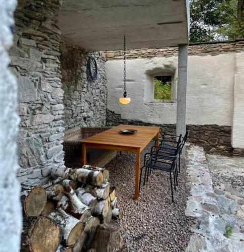a wooden table and two chairs in a stone building at Gonna Dom w Górach in Gniewoszów