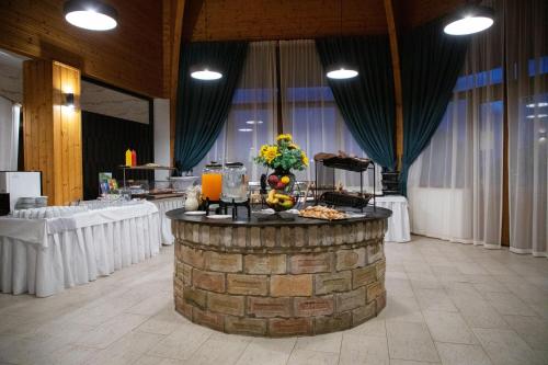 a table with food and flowers on top of a brick pillar at Hotel Rozálka in Pezinok