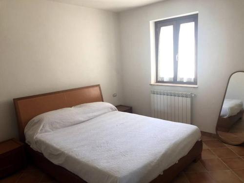 een slaapkamer met een bed en een raam bij Appartamento panoramico Terranera in Terranera