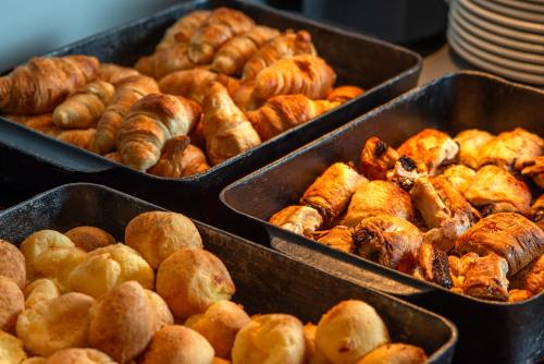 a bunch of pastries and croissants in trays at Laghetto Stilo São Paulo in Sao Paulo