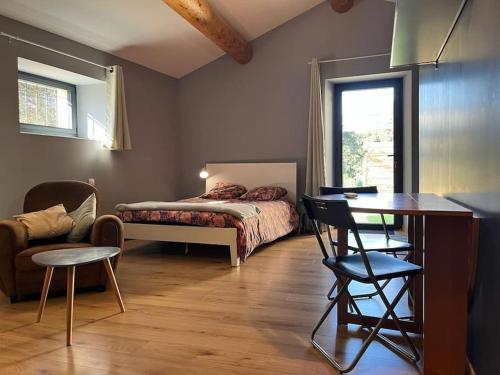 1 dormitorio con 1 cama, 1 mesa y 1 silla en Studio du petit caillou en Drôme provençale en Saint-Restitut