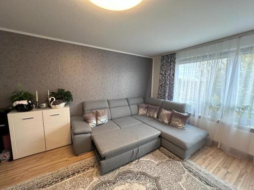 a living room with a gray couch and a large window at BS Business Travelling Hannover City in Hannover
