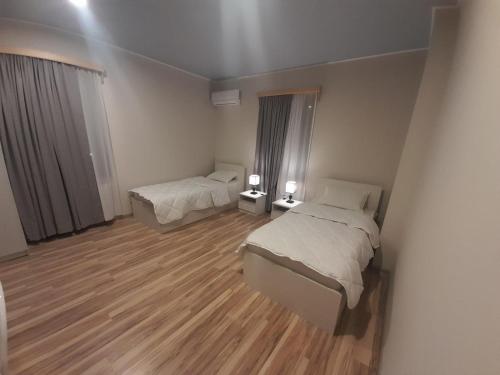 1 dormitorio con 2 camas y suelo de madera en გურია en Chʼokhatauri