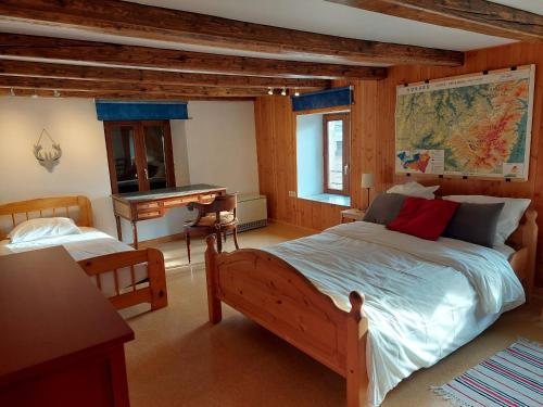 a bedroom with a large bed and a desk at Ferme des boudieres in Fresse-sur-Moselle