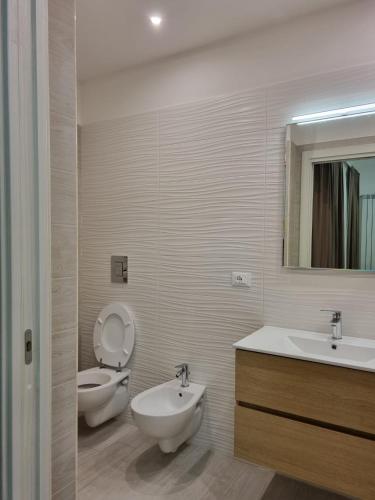 a bathroom with a toilet and a sink and a mirror at I Gerani appartamento bilocale deluxe in Vieste