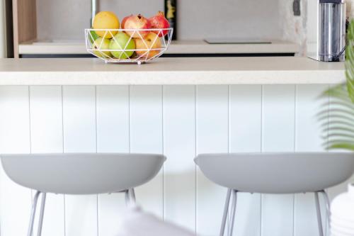 a counter with two stools and a bowl of fruit at Pithea Luxury Living in Koroni