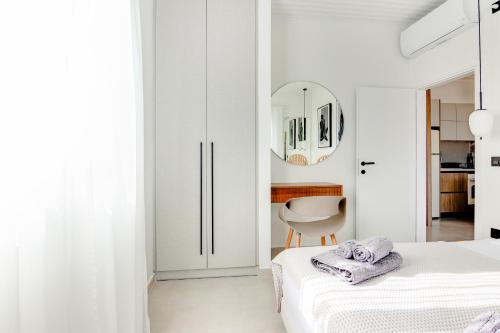biały pokój z łóżkiem i krzesłem w obiekcie Pithea Luxury Living w Koroni
