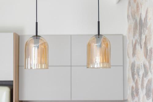 two pendant lights hanging over a kitchen counter at Pithea Luxury Living in Koroni