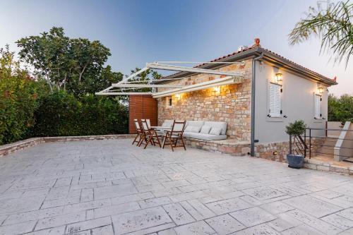 a patio with a couch and chairs in front of a building at Pithea Luxury Living in Koroni