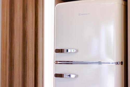 a white refrigerator freezer sitting in a kitchen at Pithea Luxury Living in Koroni