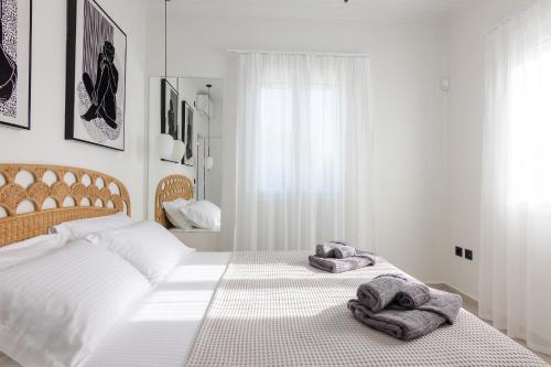a white bedroom with two towels on a bed at Pithea Luxury Living in Koroni