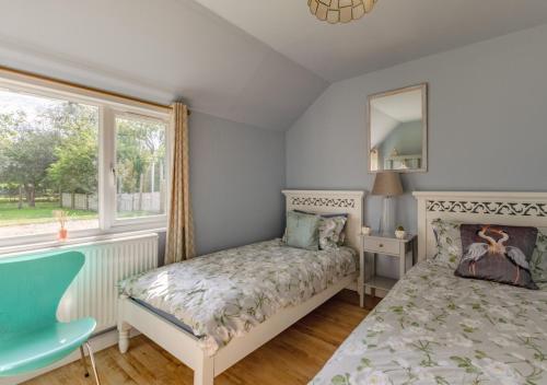 um pequeno quarto com uma cama e uma janela em Blossom Cottage em Lakenheath