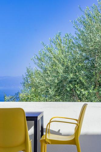 two yellow chairs and a table on a balcony at Pithea Luxury Living in Koroni
